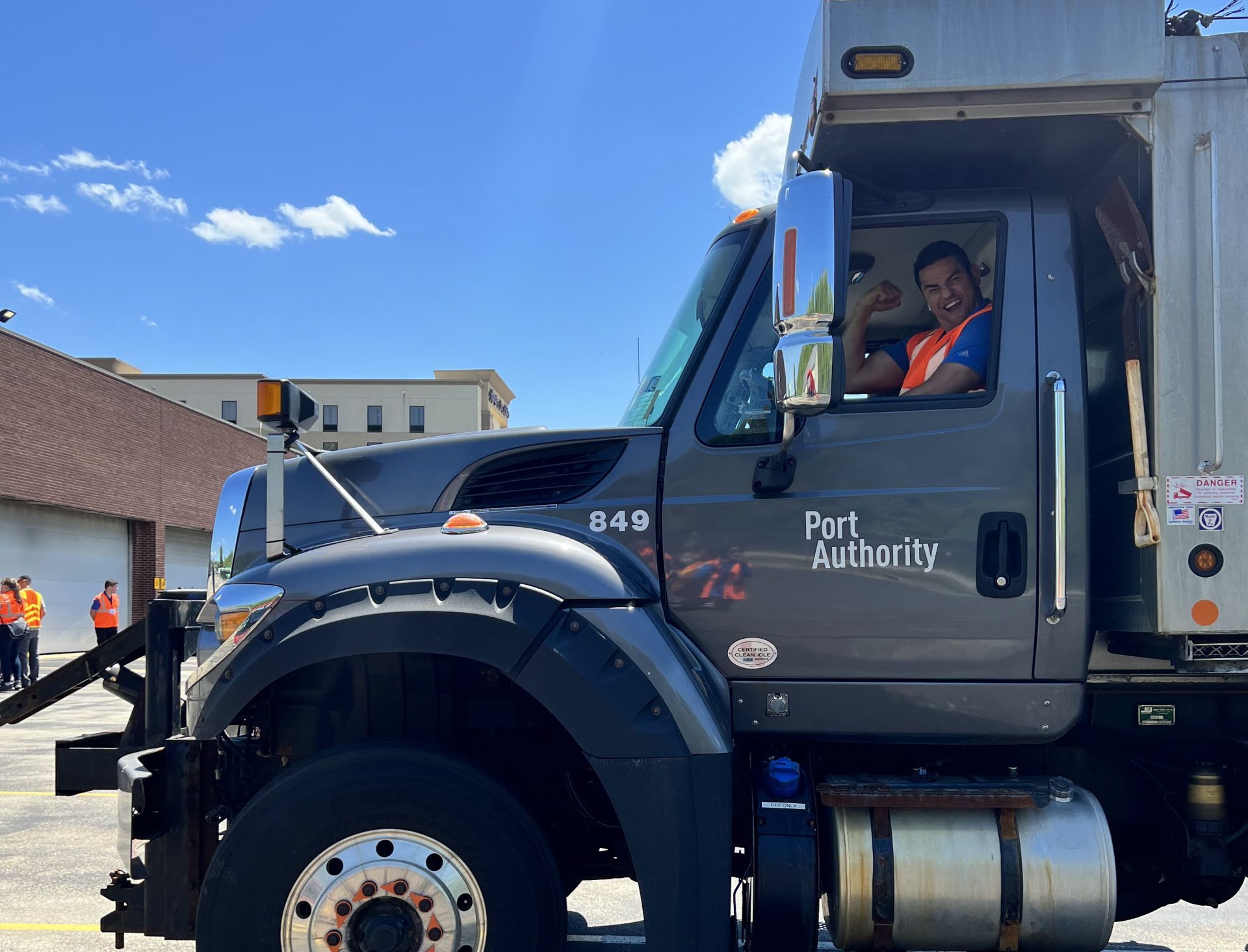 one participant in a big truck looks happy and waves at camera